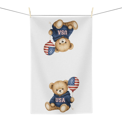 White microfiber tea towel with two watercolor teddy bears in USA sweatshirts holding flag balloons.