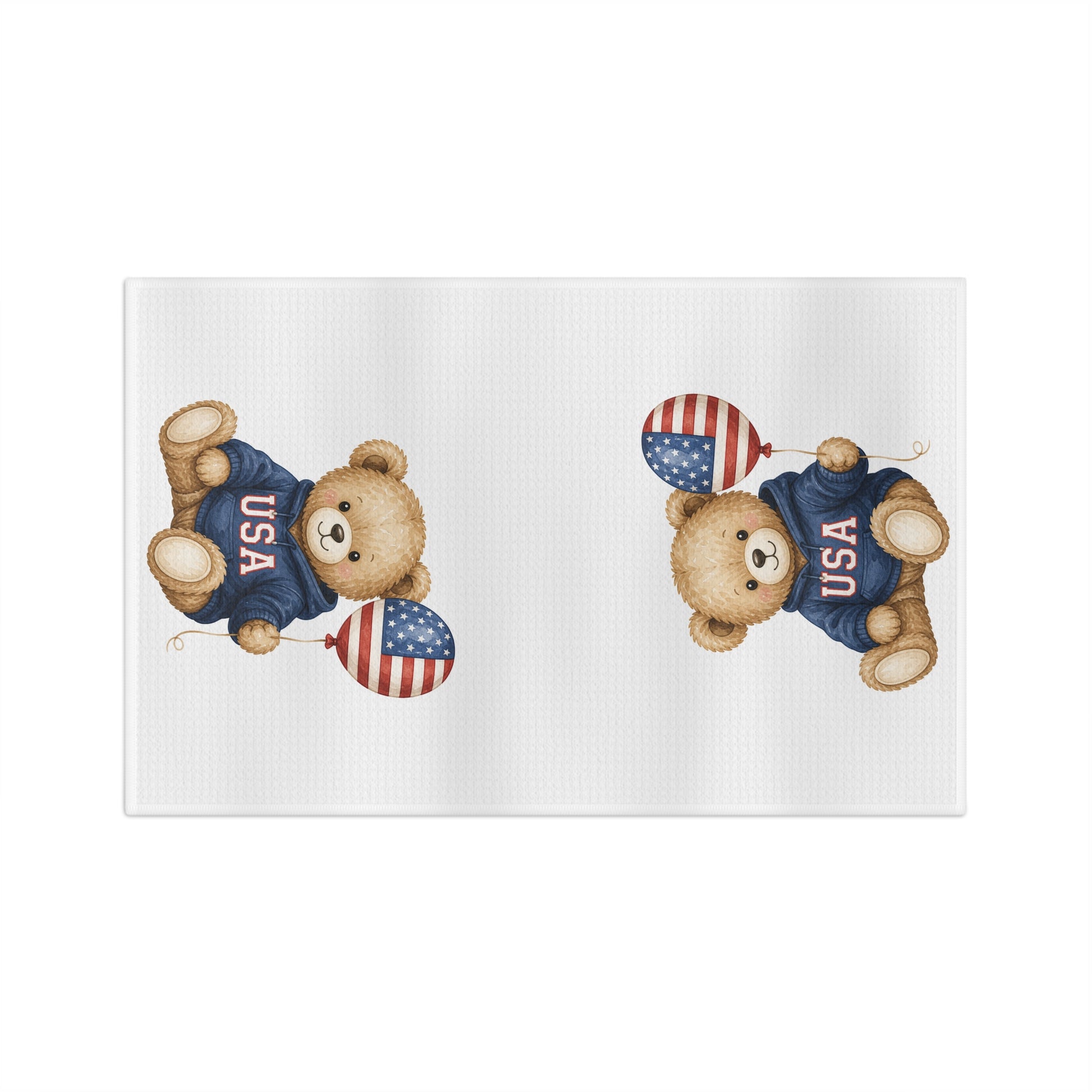 White microfiber tea towel with two watercolor-style teddy bears in USA sweatshirts holding flag balloons.