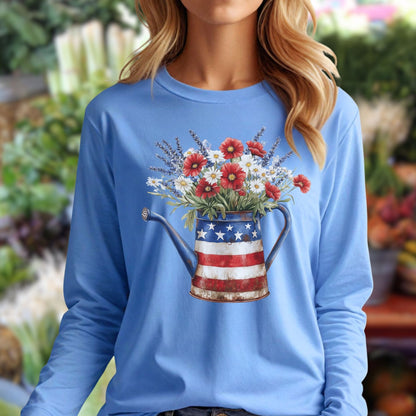 Blonde woman in a light blue long sleeve tee with a patriotic watering can and wildflowers design.