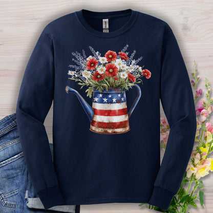 Navy long sleeve tee with a patriotic watering can holding red, white, and blue wildflowers.