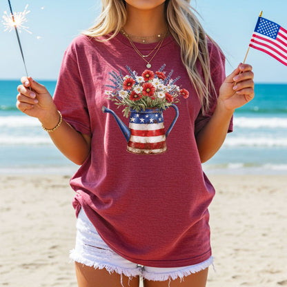 Garment-dyed t-shirt with a rustic patriotic watering can overflowing with lavender, daisies, and poppies.