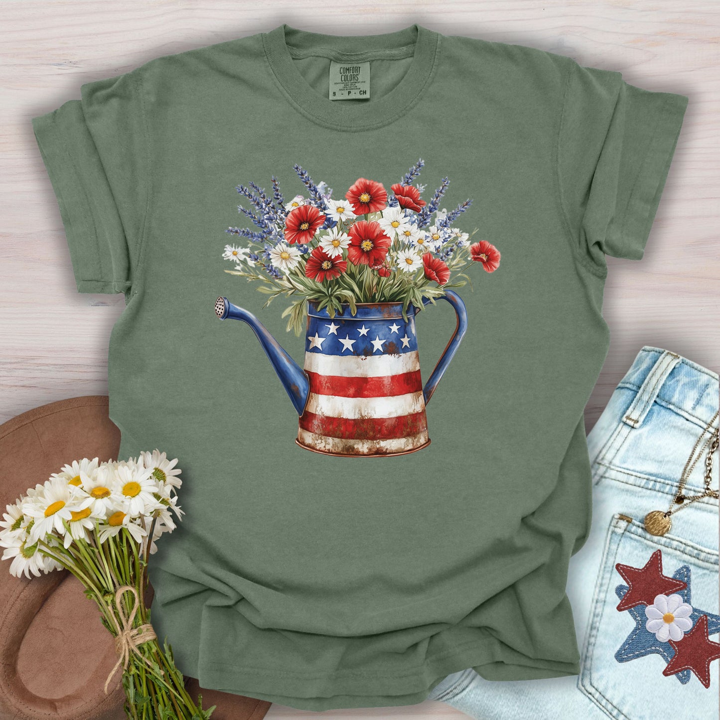 Bay green t-shirt with a rustic patriotic watering can overflowing with red poppies, white daisies, and lavender.