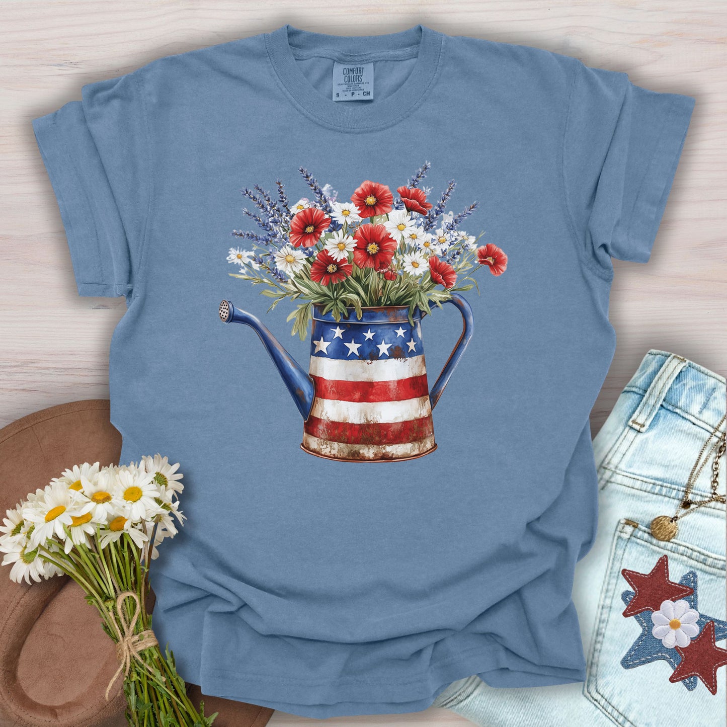 Blue Jean S t-shirt with a rustic patriotic watering can overflowing with lavender, daisies, and red poppies.