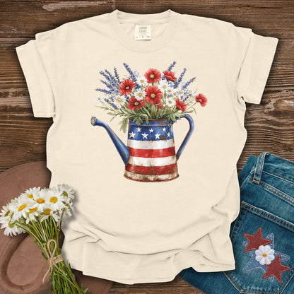 Ivory S t-shirt with a vintage patriotic watering can overflowing with lavender, daisies, and poppies.