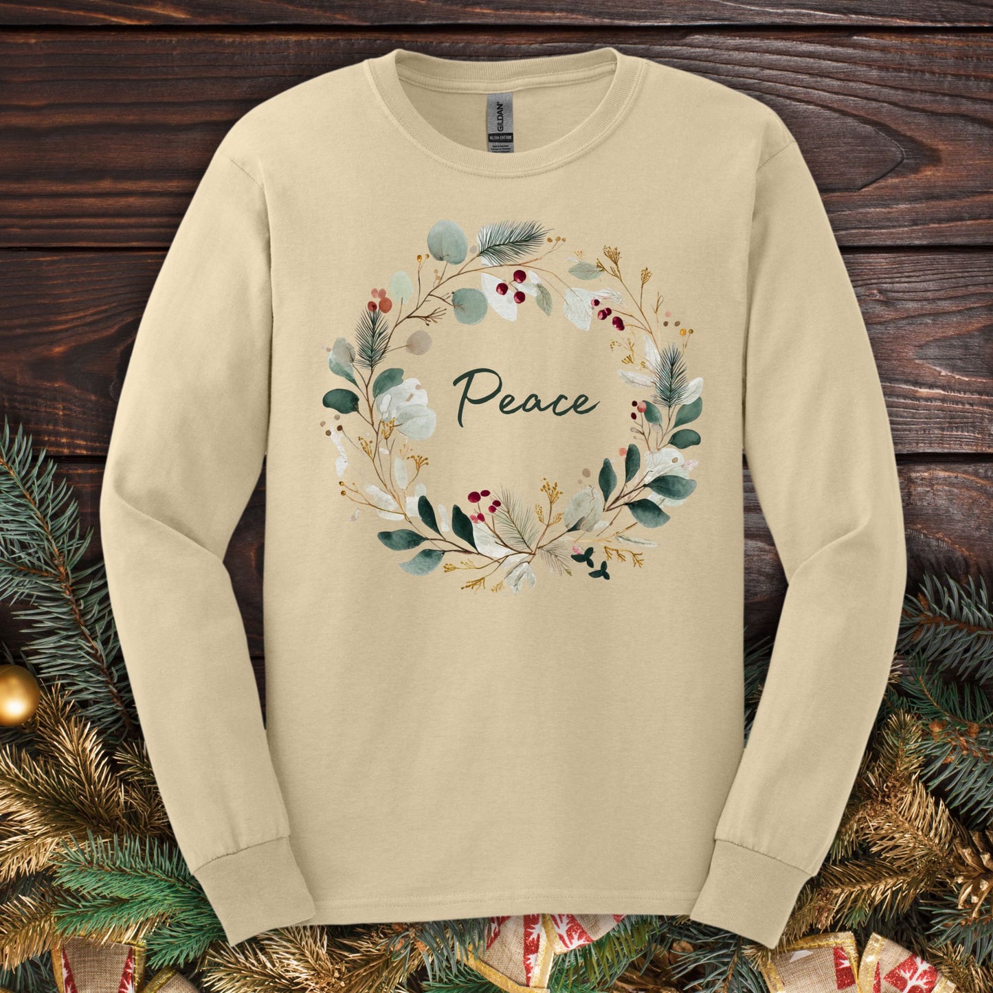 Sand Gildan long sleeve tee with a watercolor "Peace" Christmas wreath design.
