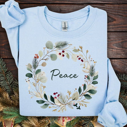Light blue Gildan sweatshirt with watercolor Christmas wreath and "Peace" in green.
