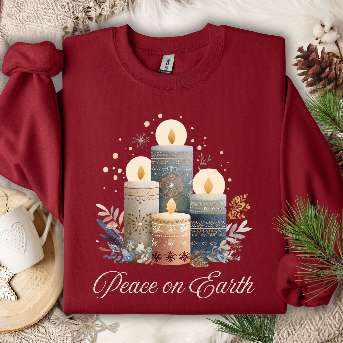Garnet sweatshirt with Nordic-style advent candles, winter foliage, and "Peace on Earth" in muted tones.