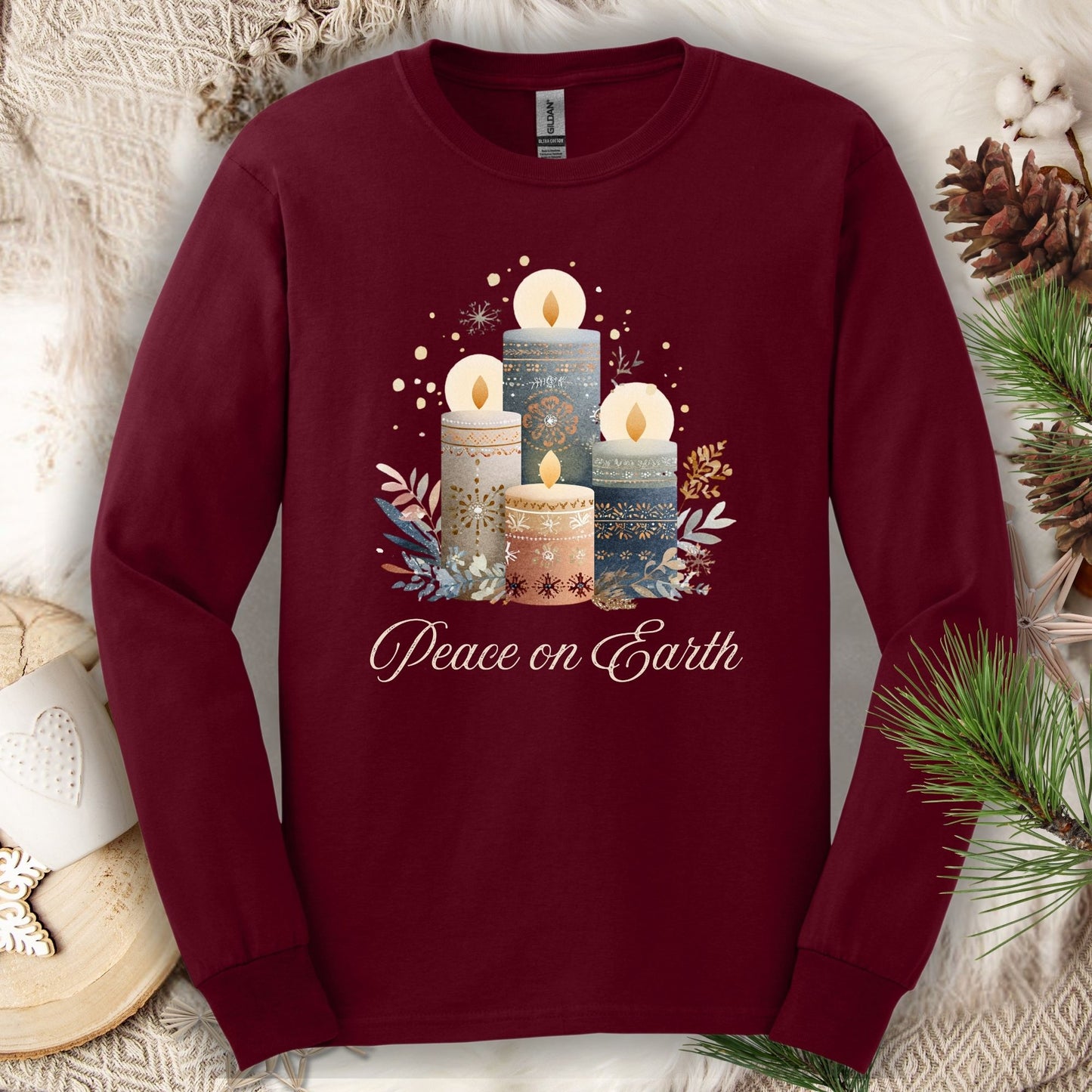 Maroon long sleeve tee with folk art Nordic advent candles and "Peace on Earth" text.