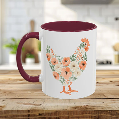 White ceramic mug with a floral chicken silhouette in coral and sage, featuring a maroon handle and interior.
