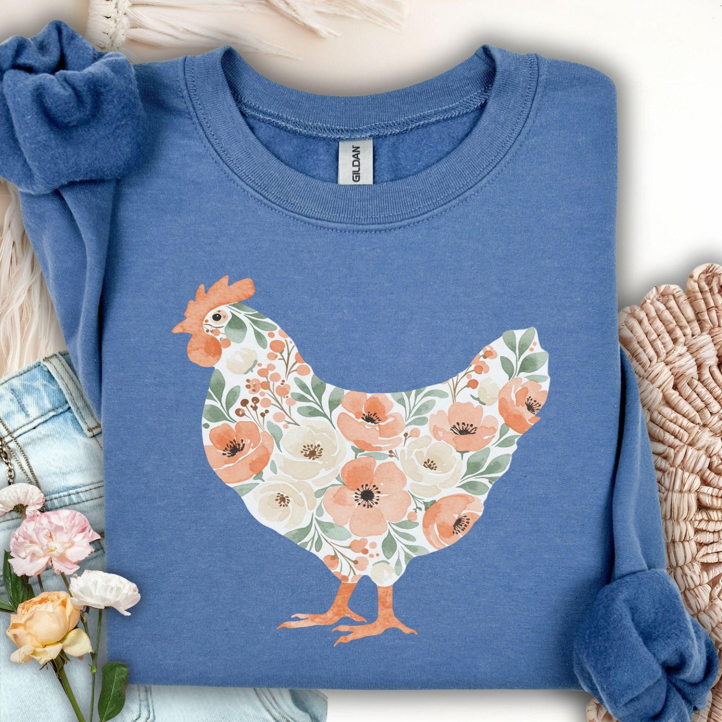 Indigo blue sweatshirt with a watercolor floral hen design in peach, cream, and green.