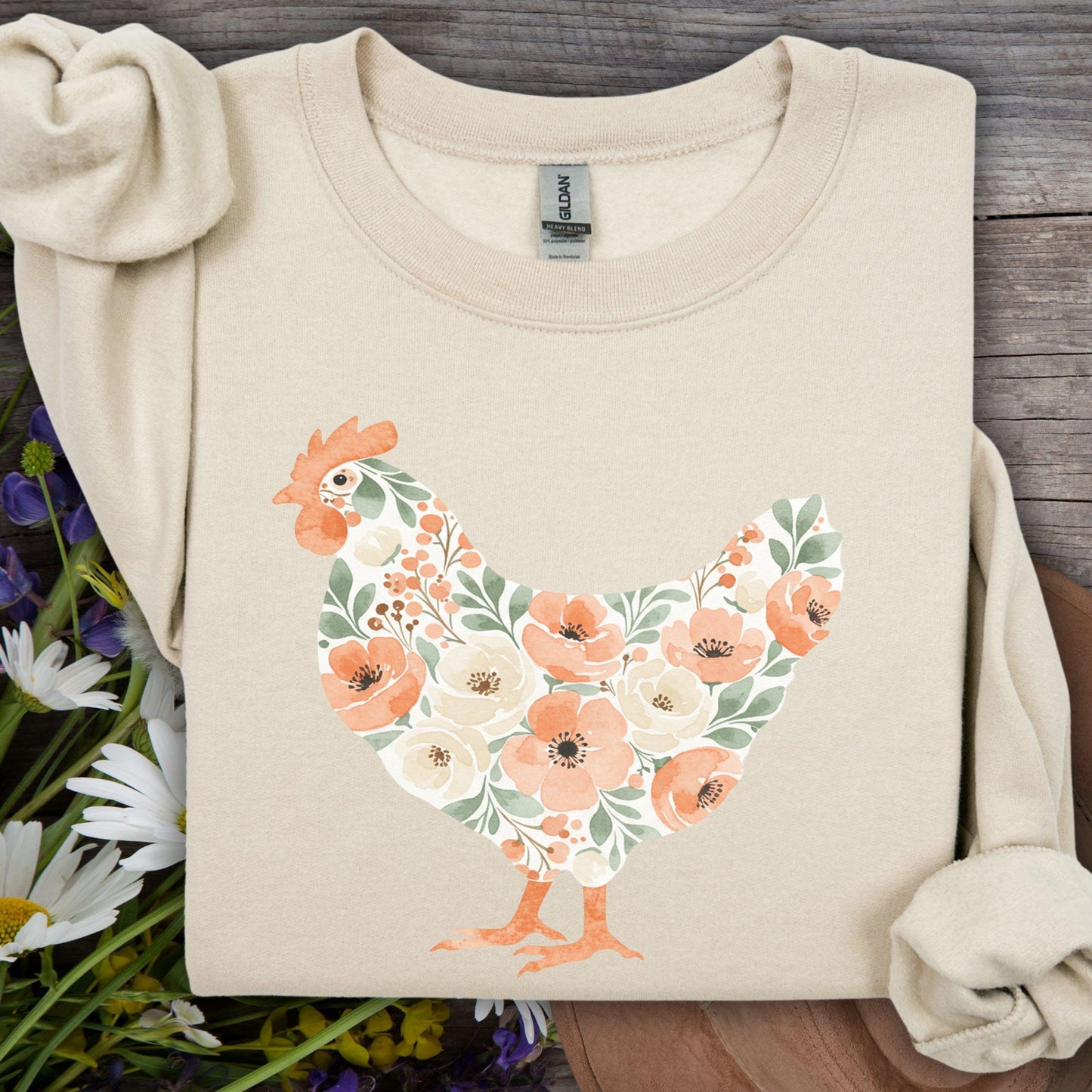 Sand sweatshirt with a watercolor floral hen design in peach, cream, and green.
