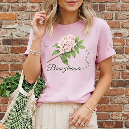 Garment-dyed pink t-shirt with a Pennsylvania outline and mountain laurel flower design.