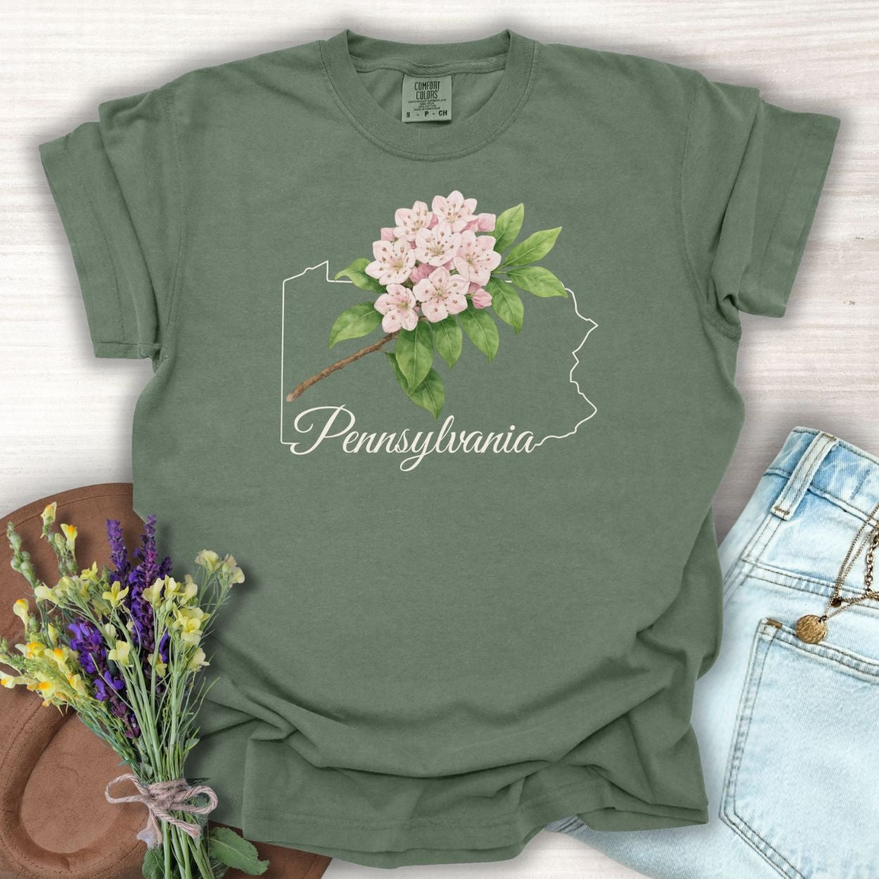 Moss green garment-dyed t-shirt with pink mountain laurel over a Pennsylvania outline.