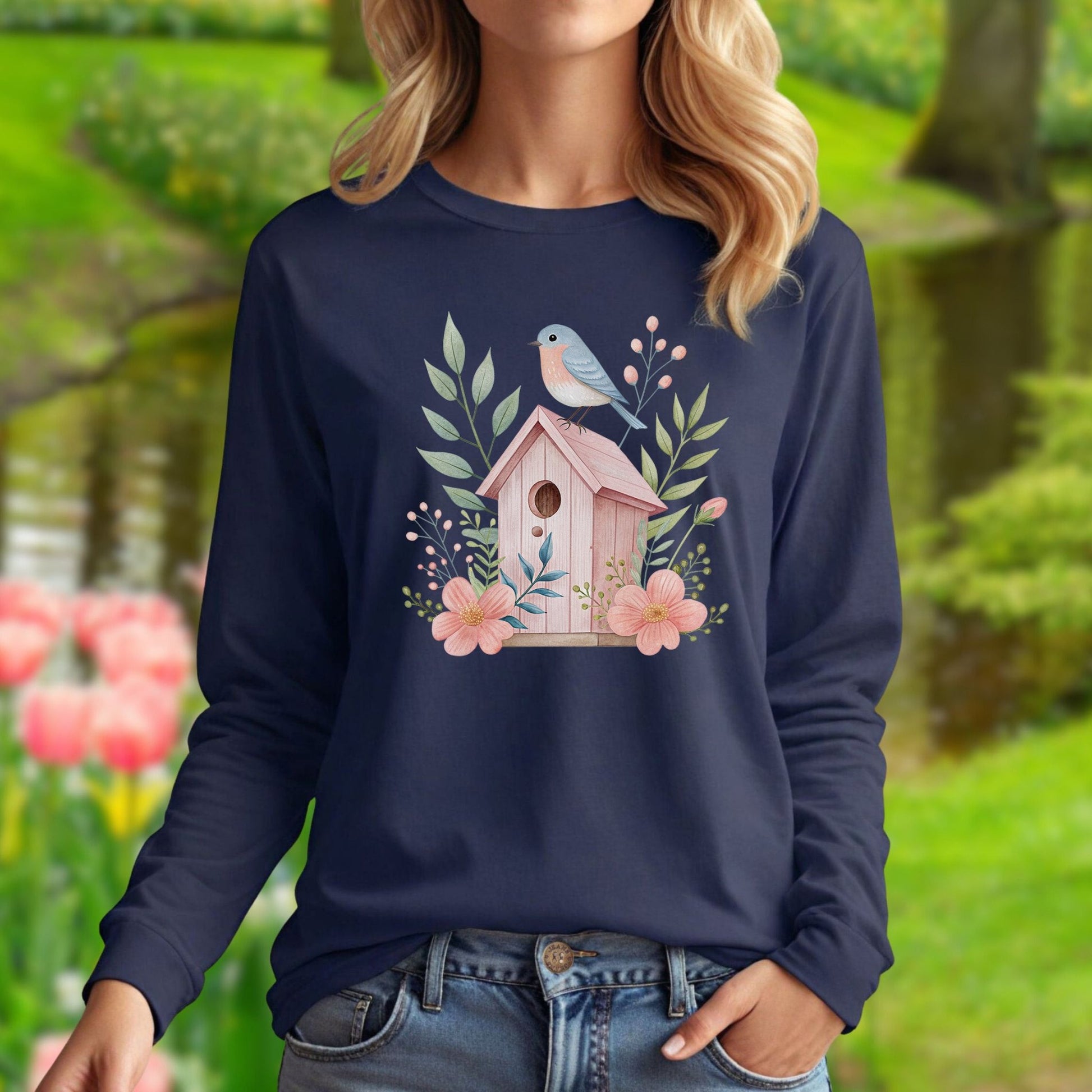 Navy long sleeve tee with a watercolor pink birdhouse, blue bird, and botanical design.