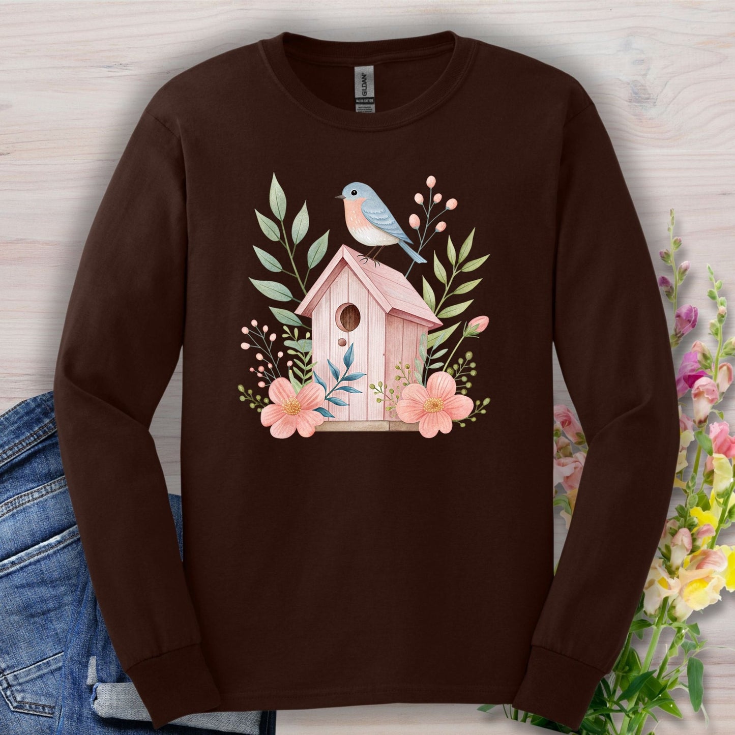 Dark Chocolate long sleeve tee with a pink birdhouse, blue bird, and botanical watercolor design.