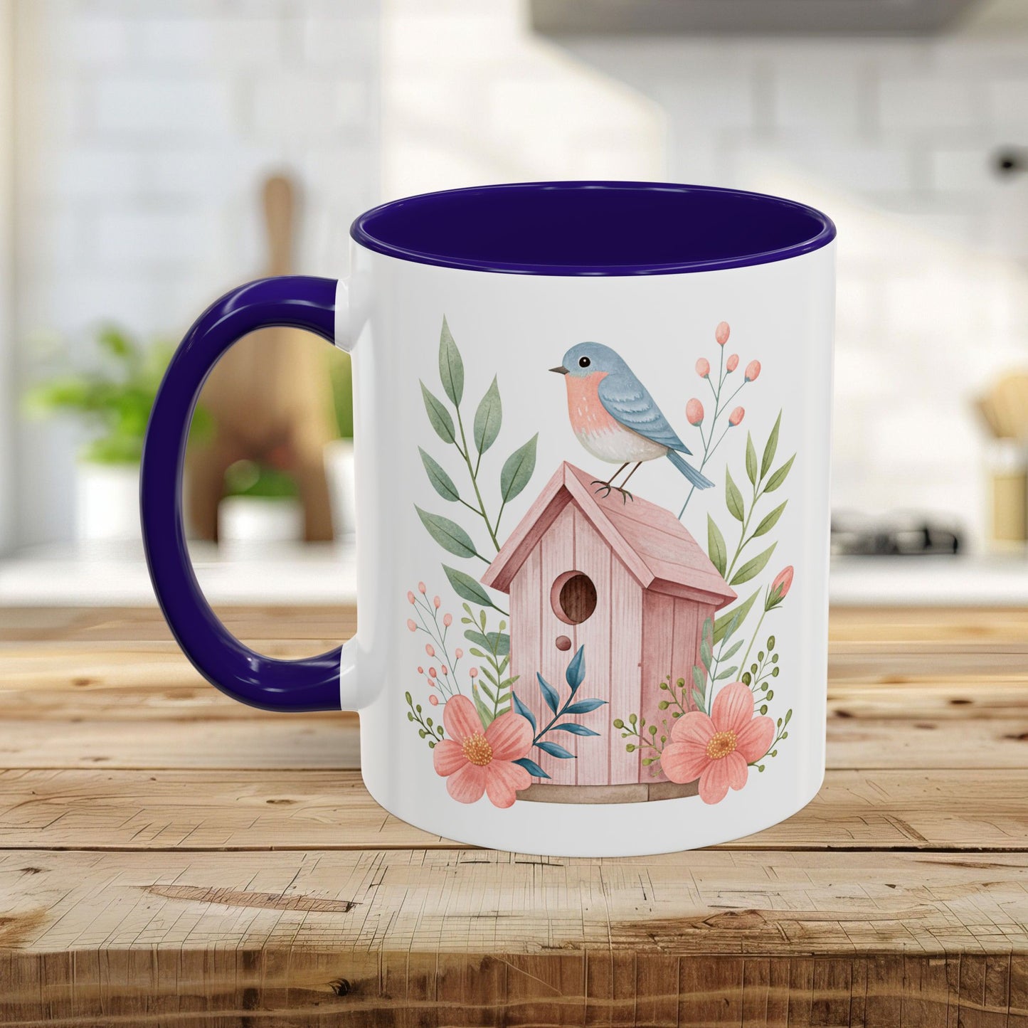 White ceramic mug with a pink birdhouse, bluebird, and peach blossoms, featuring a purple handle and interior.