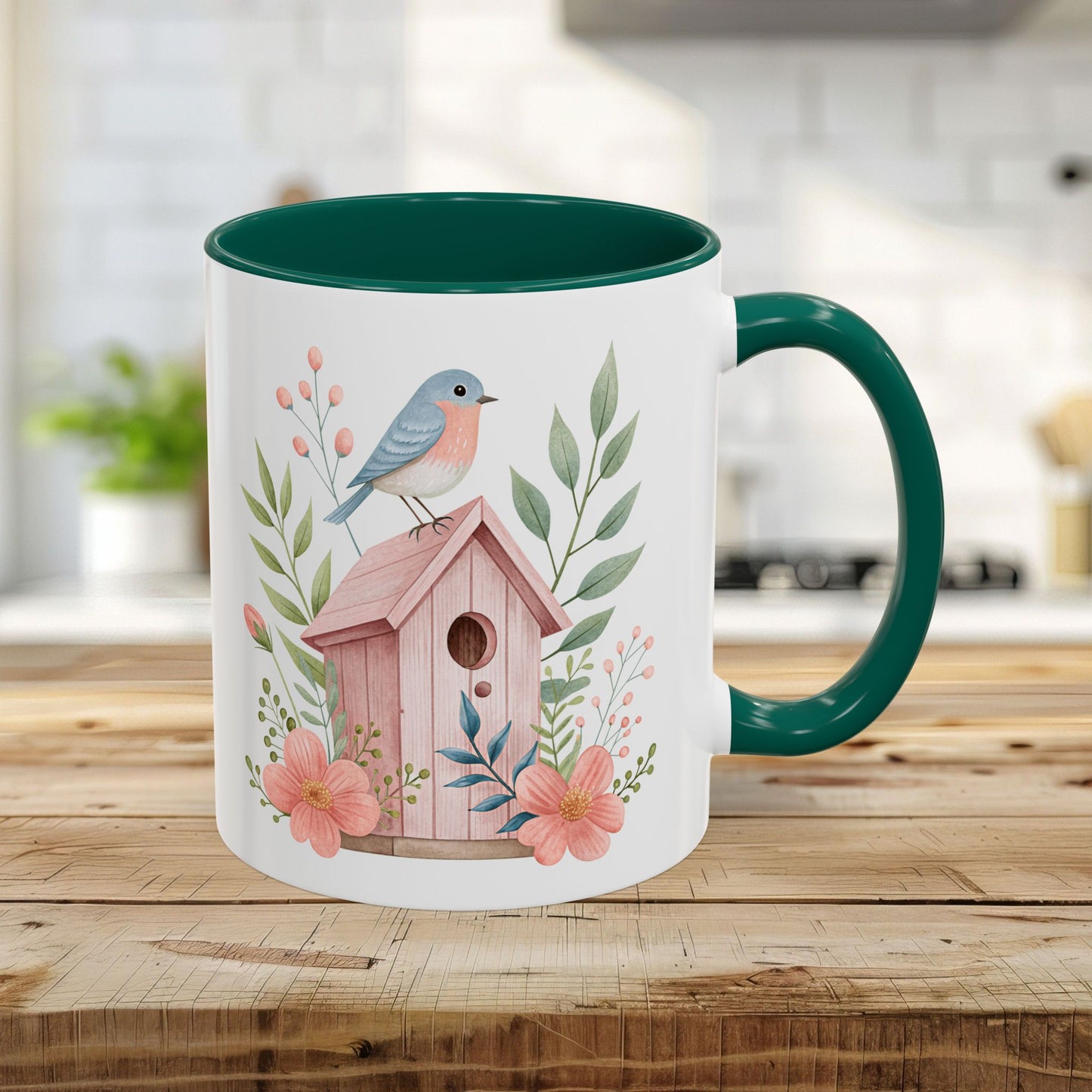 White 11oz ceramic mug with green interior/handle, featuring a watercolor bluebird on a pink birdhouse with peach blossoms.