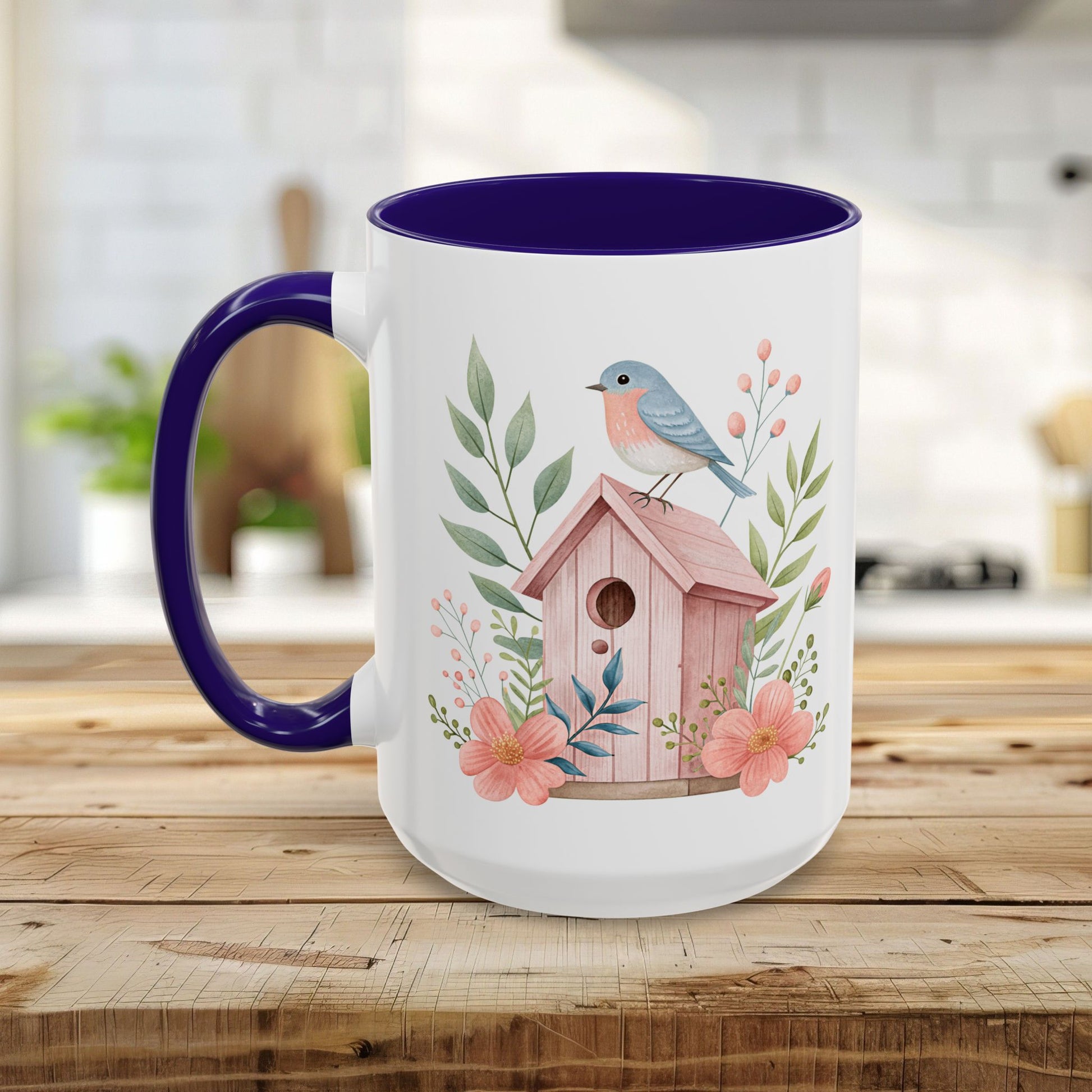 White ceramic mug with purple handle/interior, featuring a pink birdhouse, bluebird, and peach blossoms.