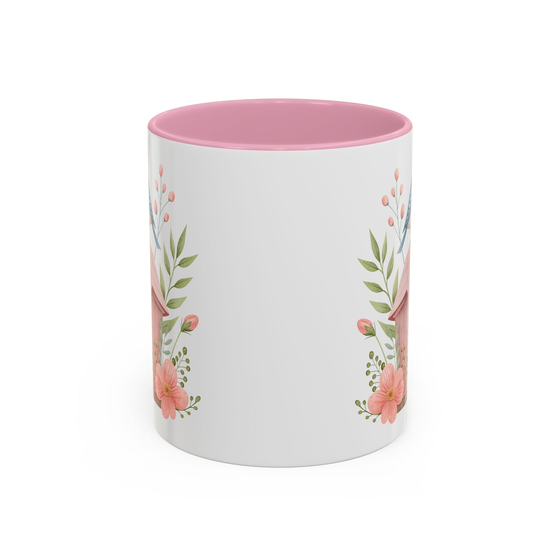 White ceramic mug with pink interior and a watercolor birdhouse, bluebird, and peach blossom design.