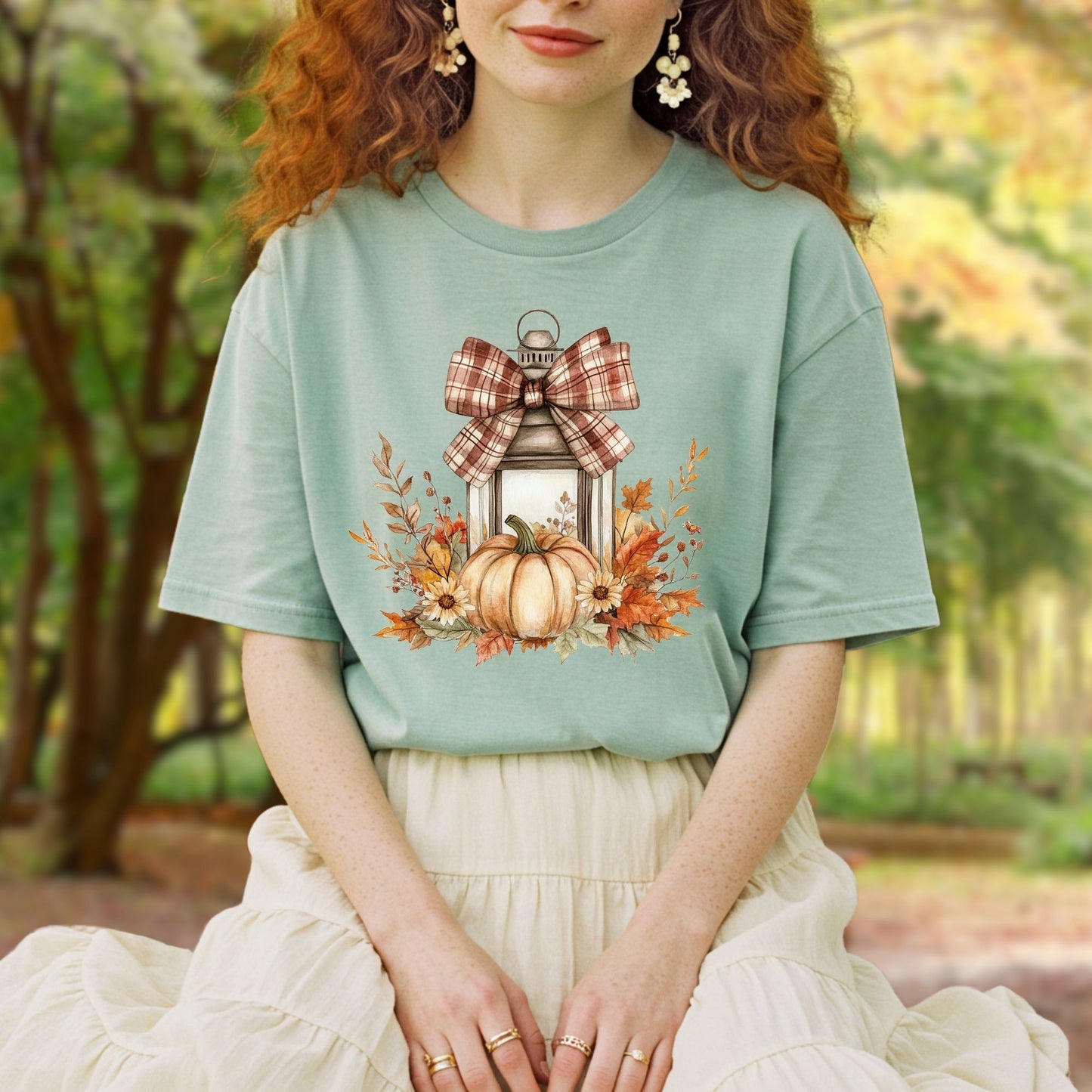 Garment-dyed tee with a rustic autumn lantern, pumpkin, sunflowers, and plaid bow design.