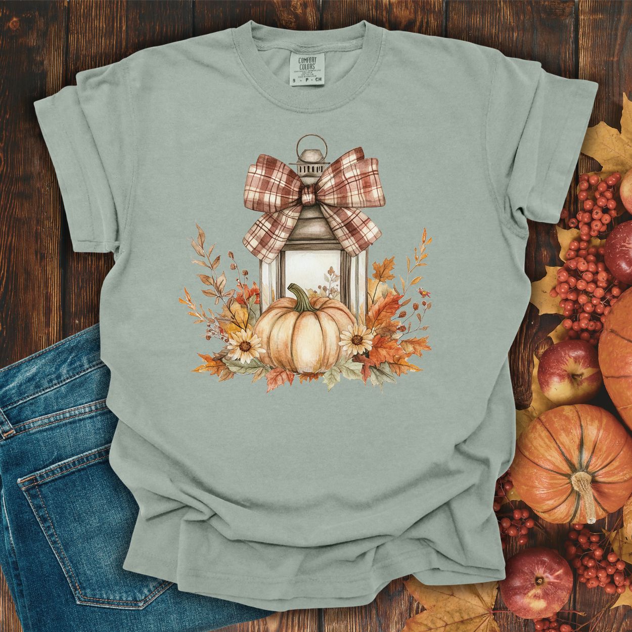 Bay green garment-dyed tee with a rustic autumn lantern, plaid bow, pumpkins, and sunflowers.