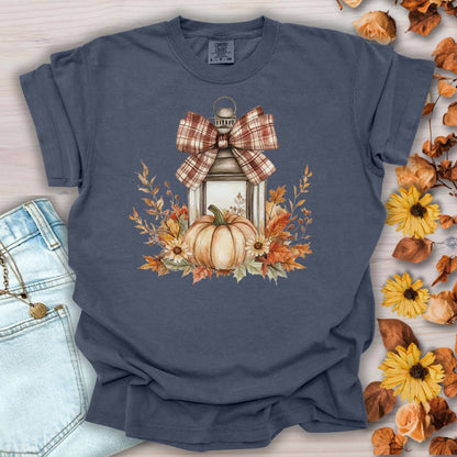 Denim blue garment-dyed tee with a rustic lantern, pumpkin, sunflowers, and plaid bow design.