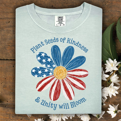 Bay Comfort Colors t-shirt with "Plant Seeds of Kindness & Unity will Bloom" and a watercolor American flag daisy.