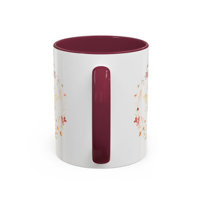 White ceramic mug with a maroon handle and interior, featuring a watercolor bee and floral wreath design.
