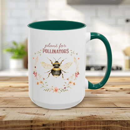 15oz white ceramic mug with green handle and interior, featuring a watercolor bee and "plant for pollinators" text.