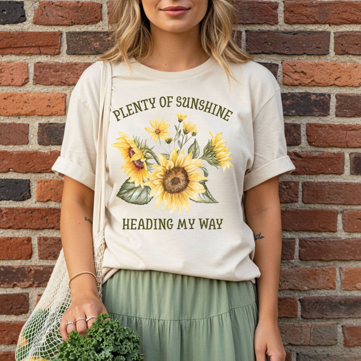 Relaxed-fit, garment-dyed cream t-shirt with "Plenty of Sunshine Heading My Way" and sunflower art.