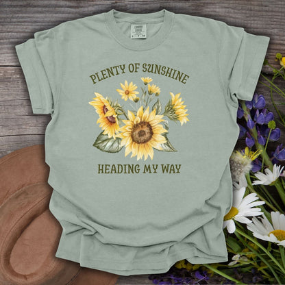 Garment-dyed Bay green t-shirt with "Plenty of Sunshine Heading My Way" text and sunflower graphic.