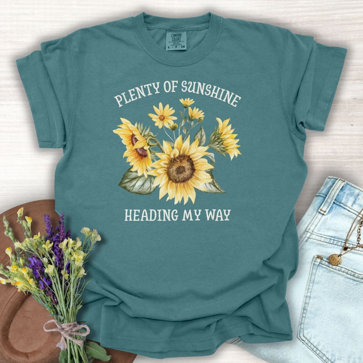 Blue Spruce garment-dyed cotton t-shirt with "Plenty of Sunshine Heading My Way" and sunflower graphic.