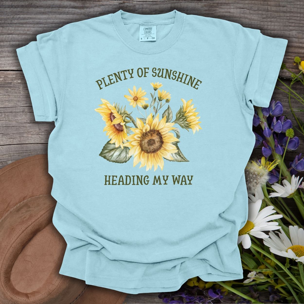Chambray blue garment-dyed t-shirt with "Plenty of Sunshine Heading My Way" and sunflower graphic.