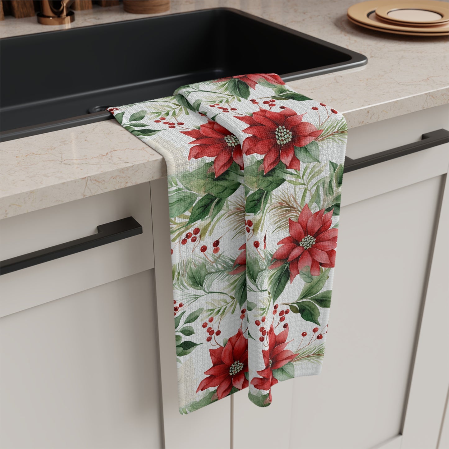 Microfiber tea towel with a vibrant watercolor poinsettia and berry print, draped over a kitchen sink.
