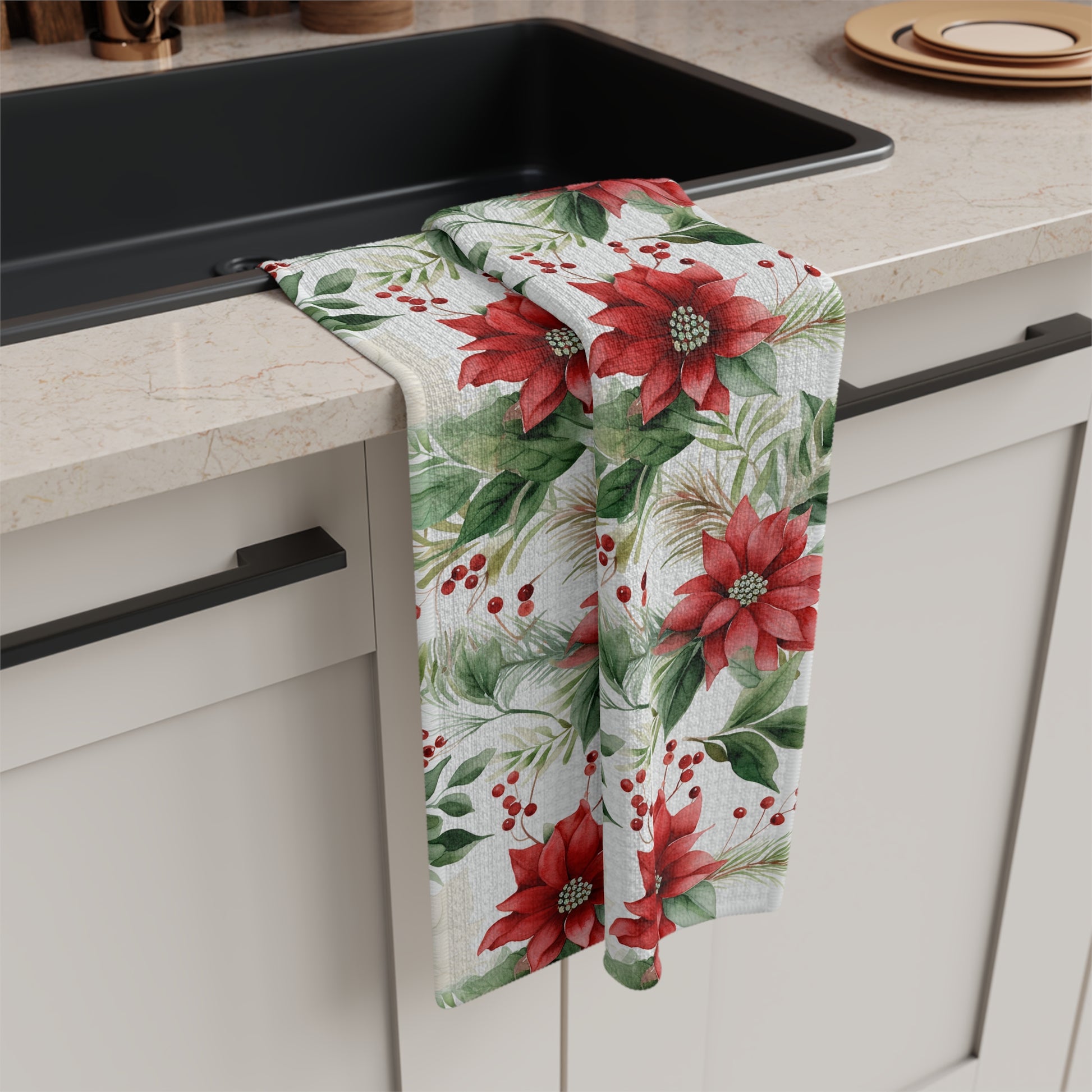 Microfiber tea towel with a vibrant watercolor poinsettia and berry print, draped over a kitchen sink.