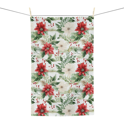 Microfiber tea towel with a vibrant watercolor poinsettia and evergreen print, hanging on a clothesline.