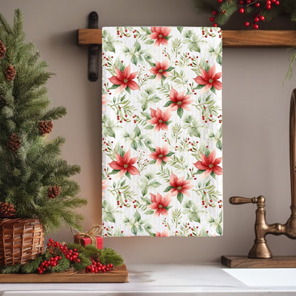 Poinsettia watercolor microfiber tea towel with red and green floral design, hanging in a festive kitchen.