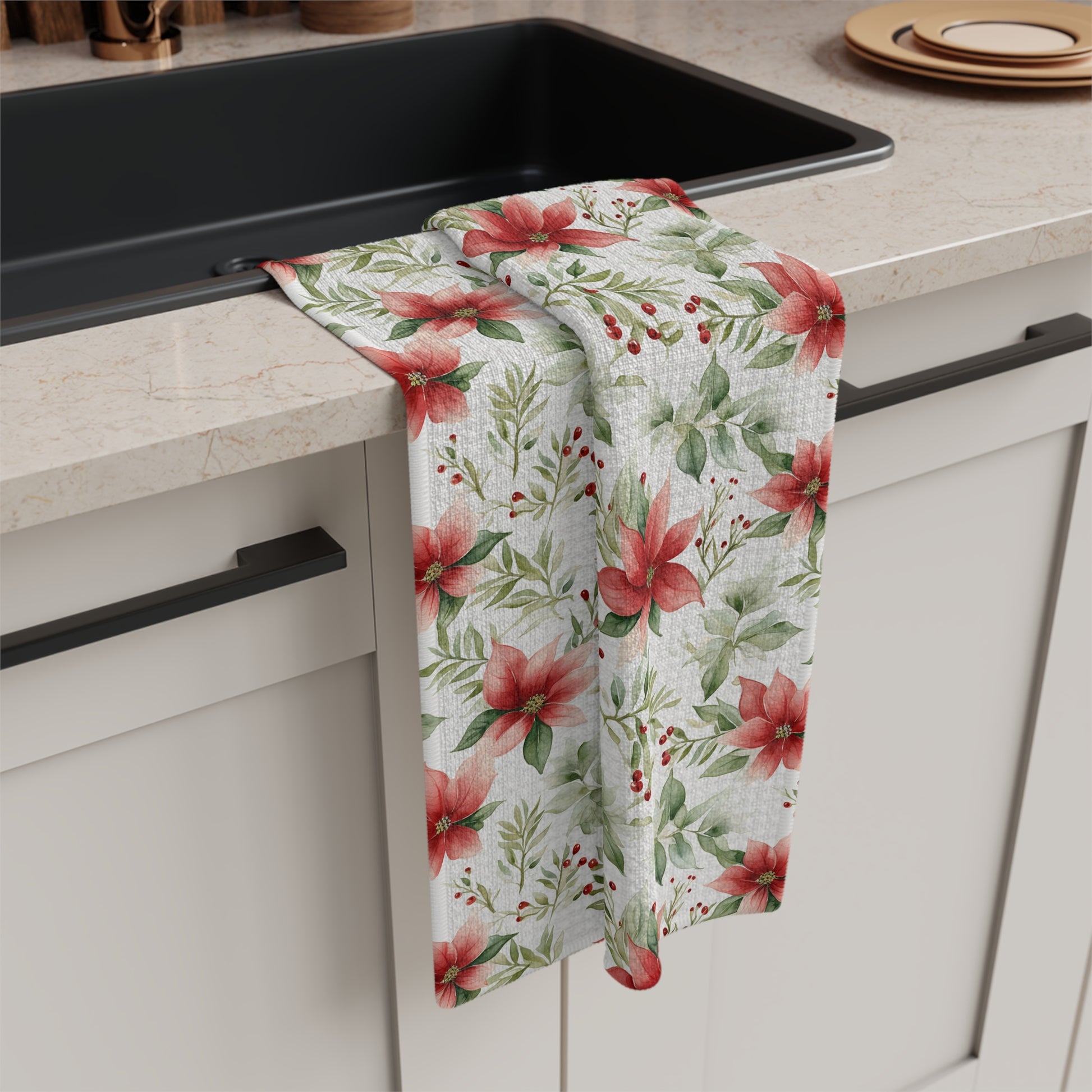 Microfiber tea towel with a watercolor poinsettia and berry design, draped over a kitchen sink.