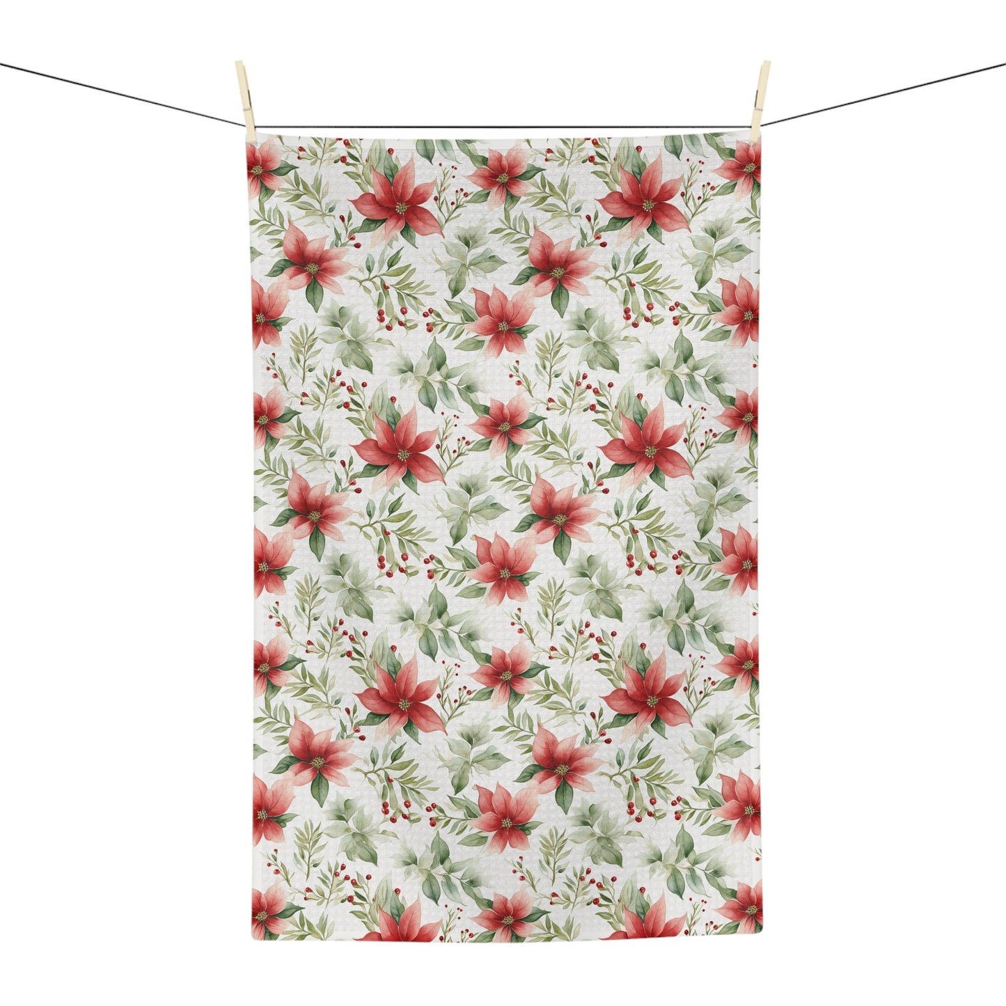 Poinsettia watercolor microfiber tea towel with red and green floral pattern, hanging on a clothesline.
