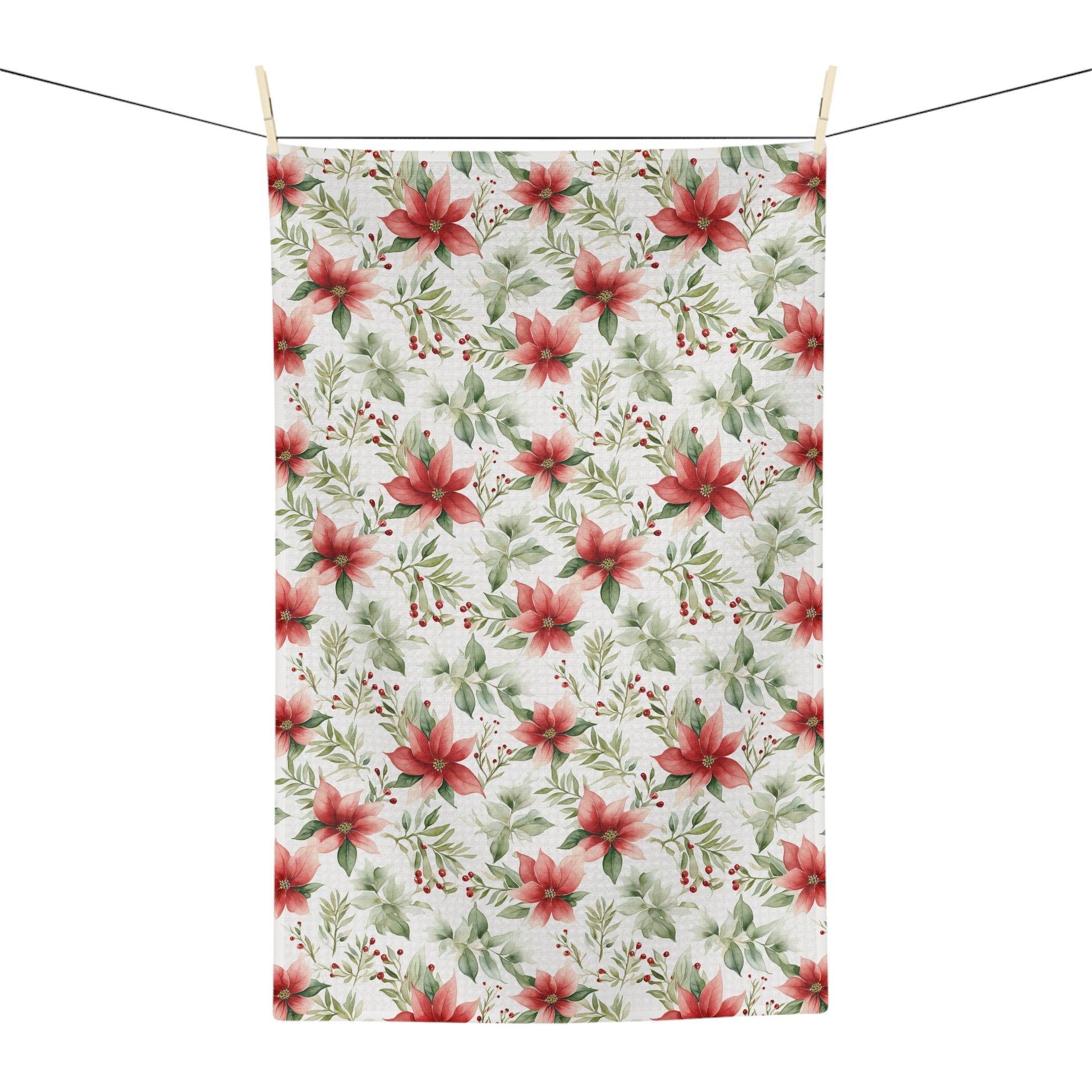 Poinsettia watercolor microfiber tea towel with red and green floral pattern, hanging on a clothesline.