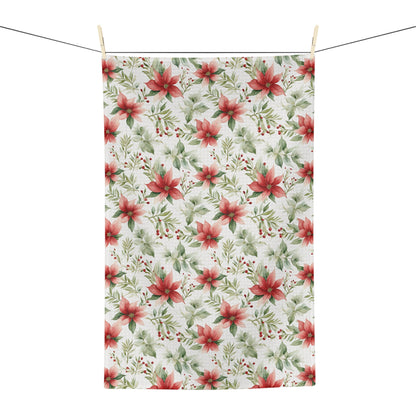 Poinsettia watercolor microfiber tea towel with red and green floral pattern, hanging on a clothesline.