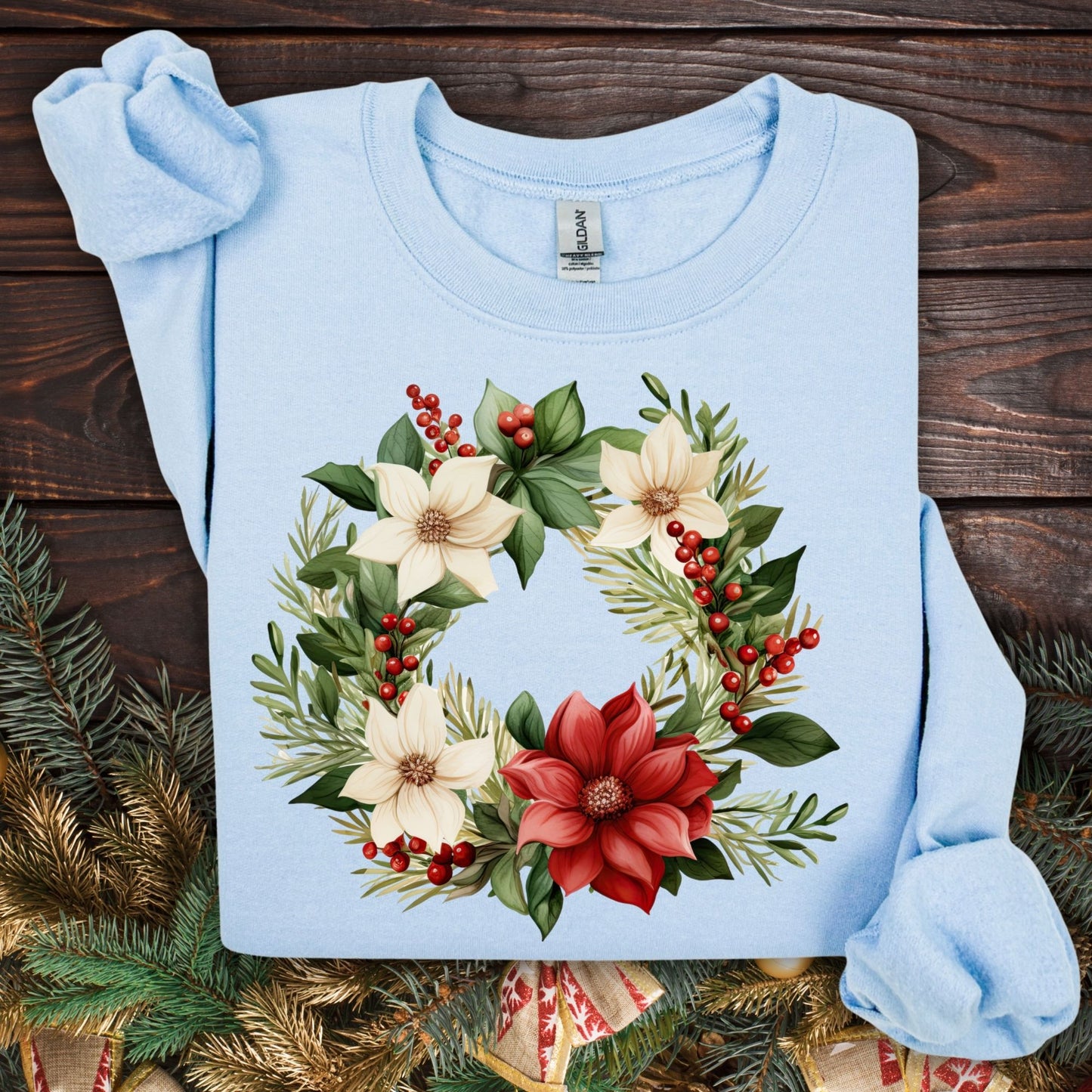 Light blue Gildan crewneck sweatshirt (S) with a watercolor poinsettia wreath design featuring red, cream, and green.