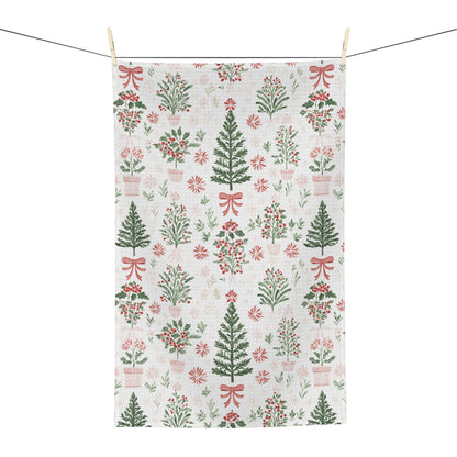 Microfiber tea towel with vintage-inspired Christmas trees, holly, and red bows on a light background.