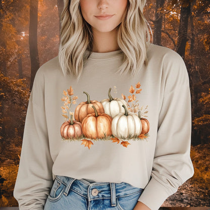 Beige long sleeve tee with watercolor orange and white pumpkins, worn by a blonde woman.
