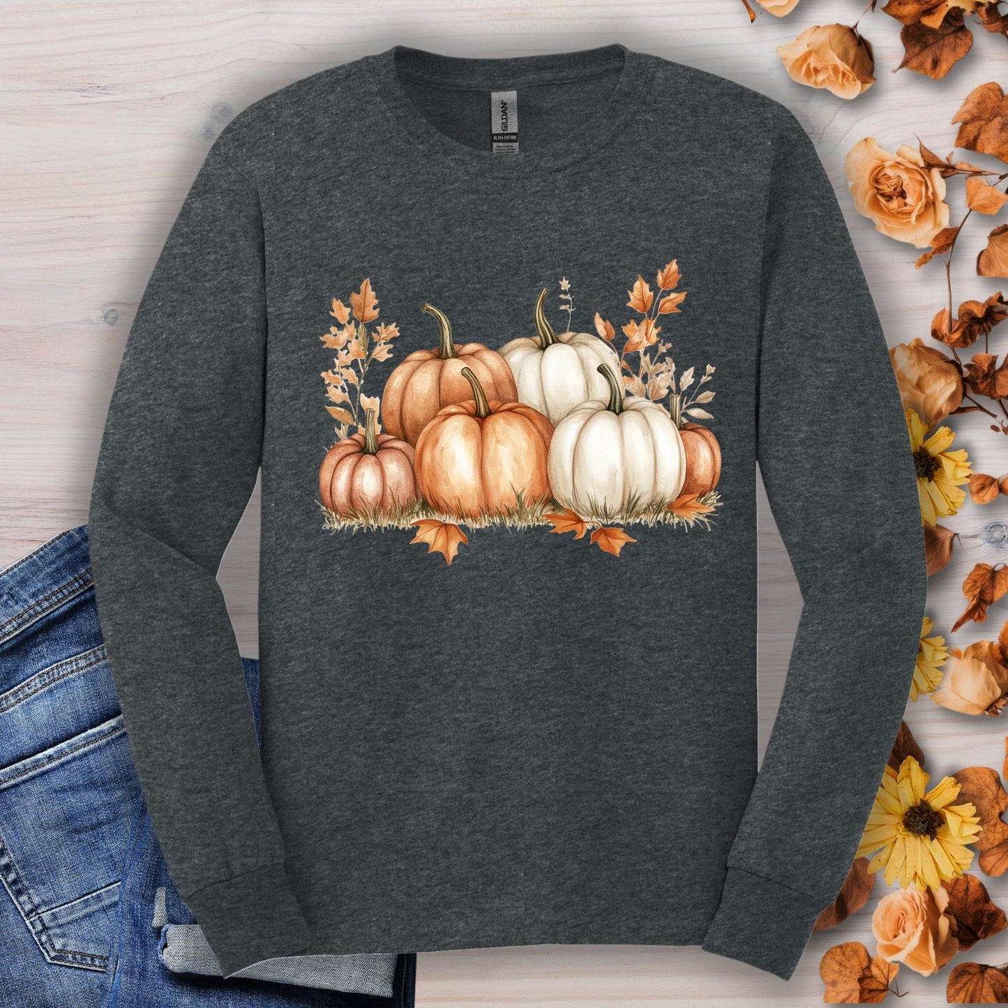 Dark heather Gildan 2400 long sleeve tee with watercolor orange and white pumpkins, surrounded by autumn leaves.