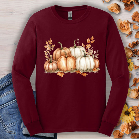 Maroon Gildan 2400 long sleeve tee with watercolor orange and white pumpkins, surrounded by autumn leaves.