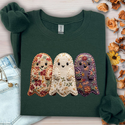 Forest Green Gildan sweatshirt with three embroidered floral fabric ghosts, light wash jeans, and autumn leaves.
