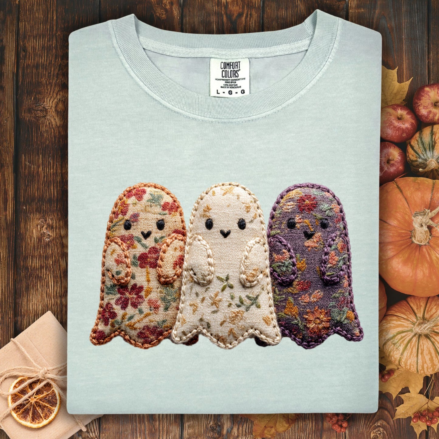 Bay Comfort Colors t-shirt with three embroidered floral fabric ghosts, surrounded by fall decor.