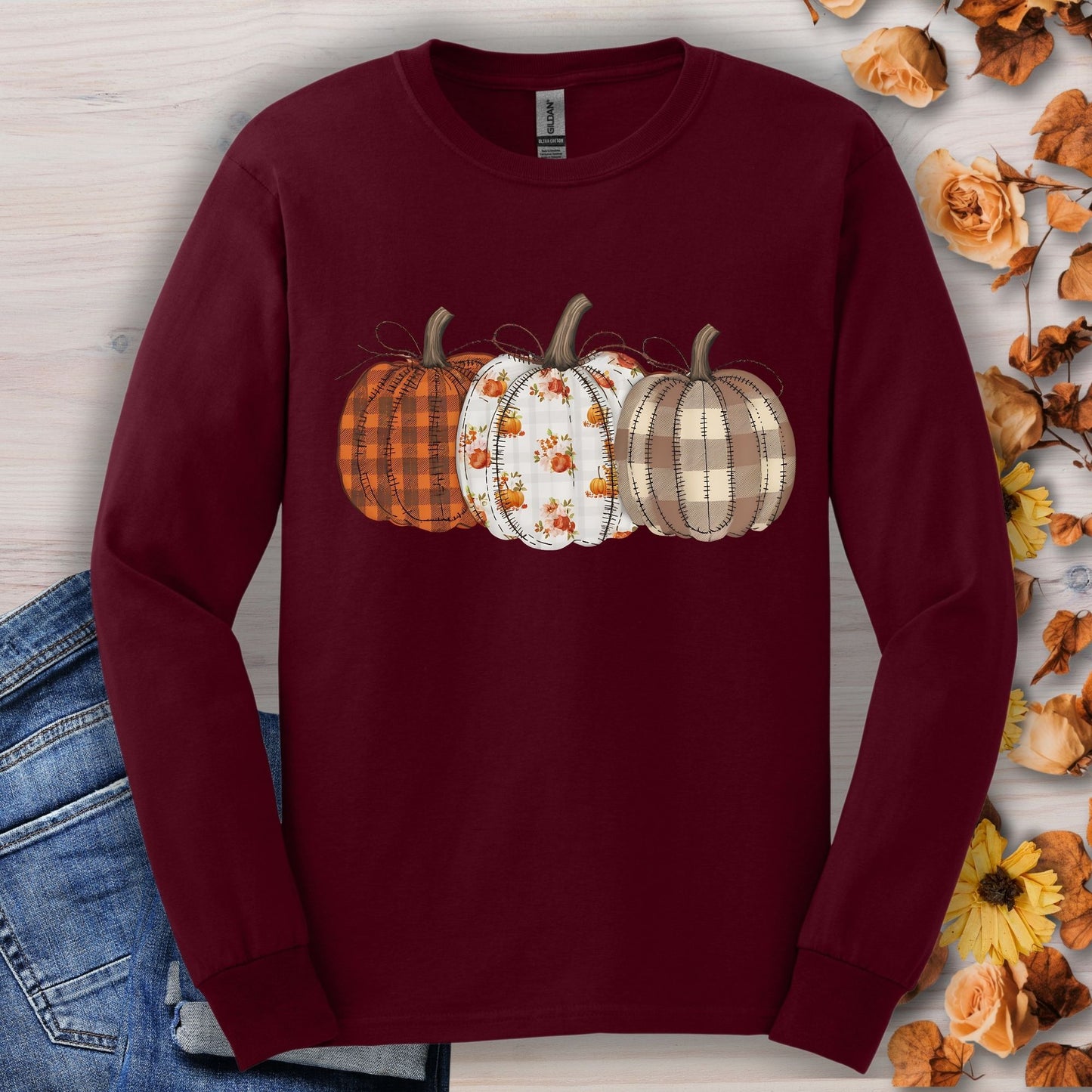 Maroon long sleeve tee with 3 cottagecore quilted pumpkins in plaid and floral patterns.