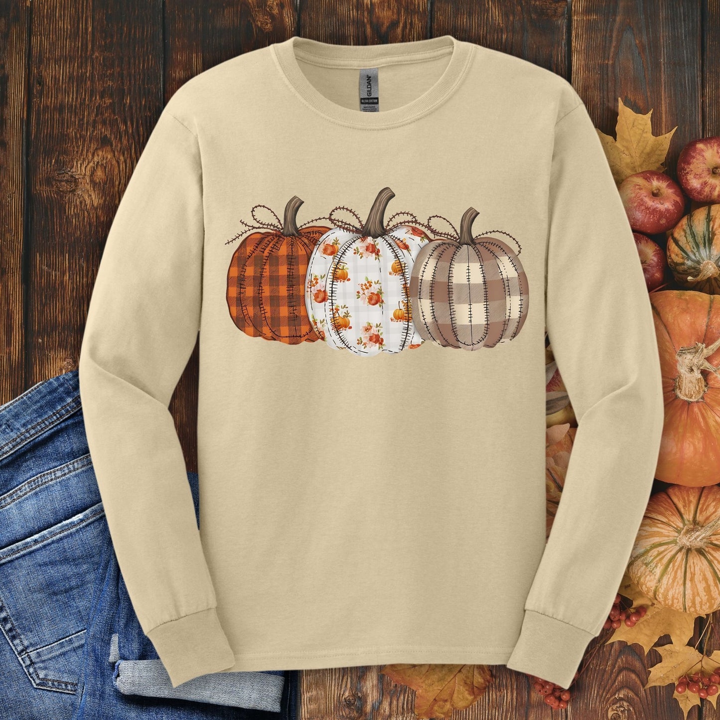 Sand long sleeve tee with 3 quilted pumpkins in plaid, floral, and striped patterns.